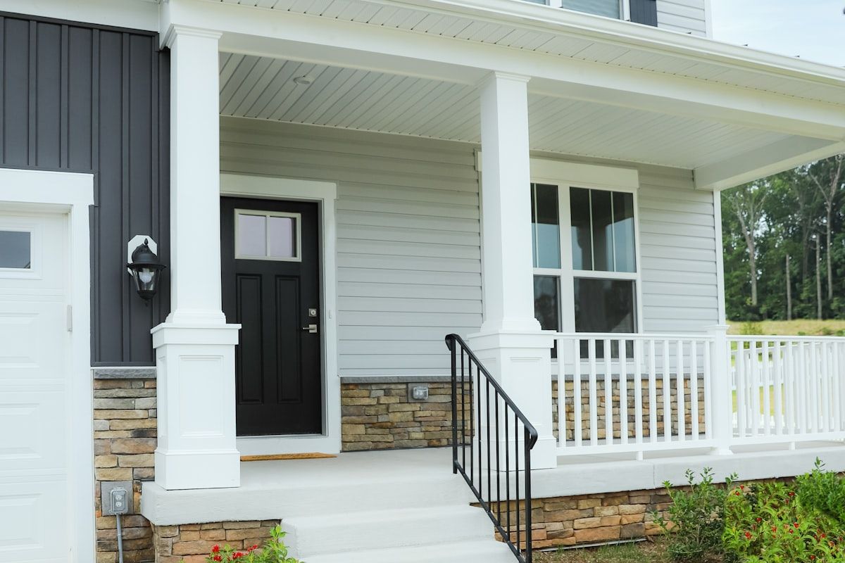 Front porch with a black entry door and white columns.