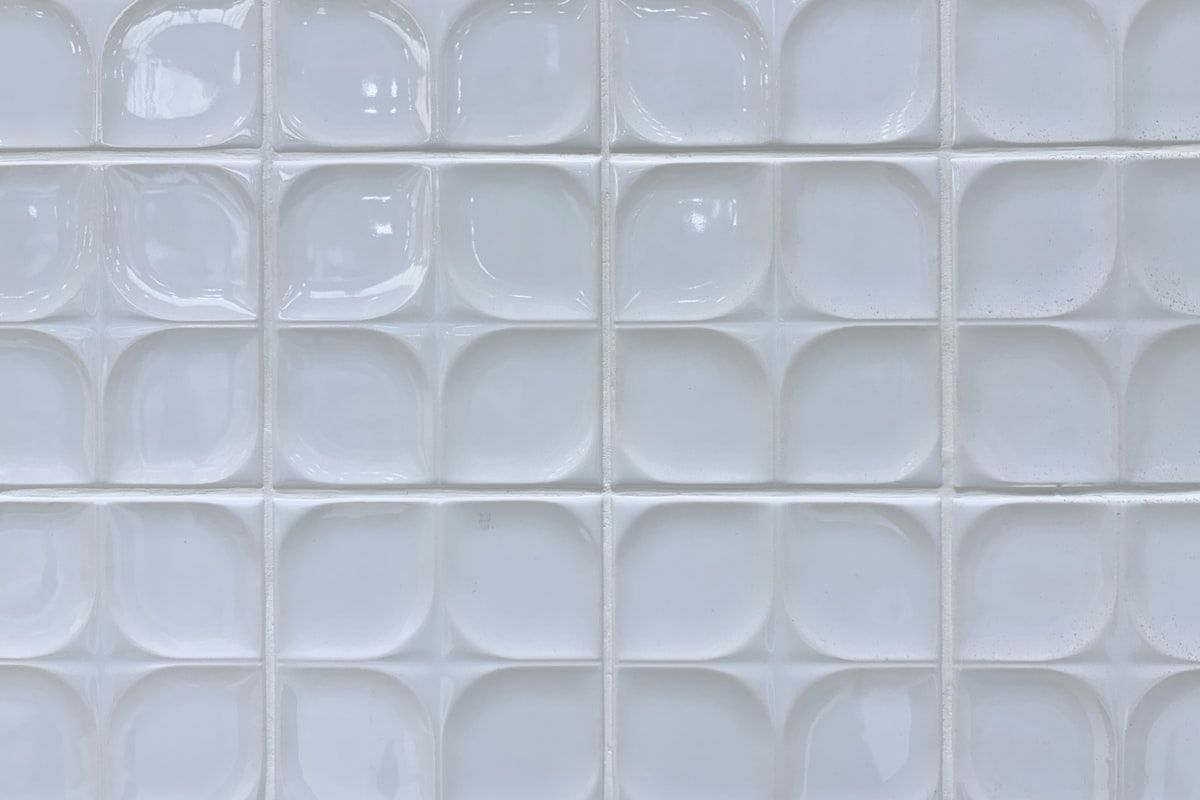 Glossy white square tile with soft beveled edges.